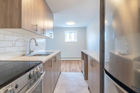 A kitchen with a stove top oven and a refrigerator.