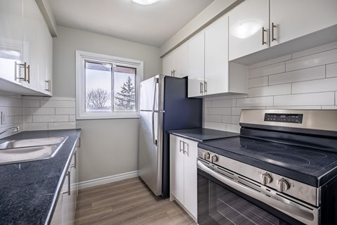 A kitchen with a black stove top oven and white cabinets.