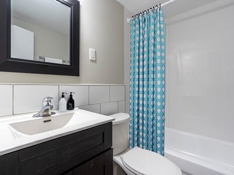 A white toilet sits next to a sink in a bathroom.