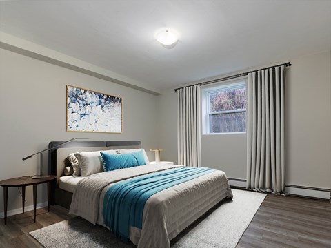 A bedroom with a large bed and a painting on the wall.