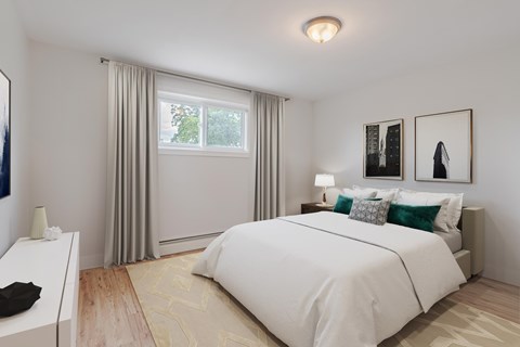 A bedroom with a large bed and a window with curtains.