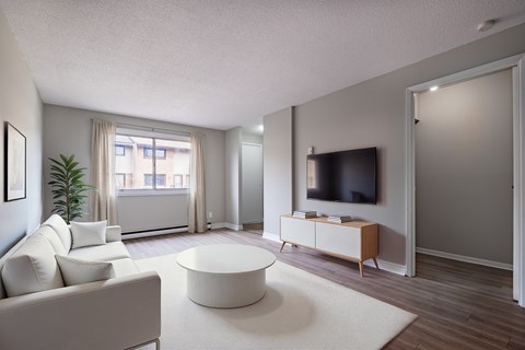 A living room with a white couch and a television.