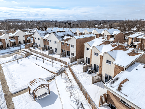 A snow-covered residential area with houses and a gazebo.