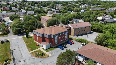A red brick building with a parking lot in front.
