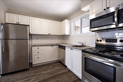 A kitchen with white cabinets and stainless steel appliances.
