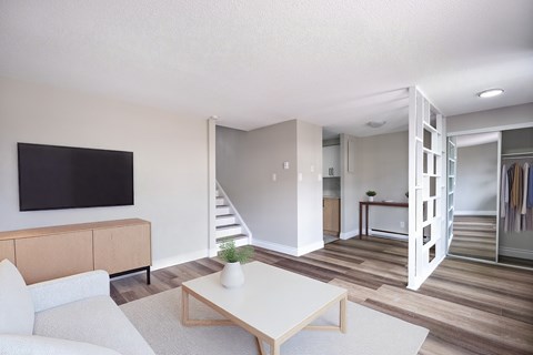 A living room with a white couch and a wooden coffee table.