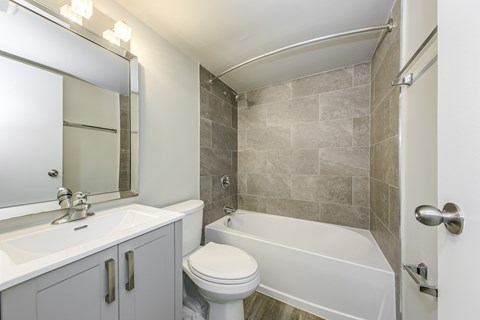 A bathroom with a white toilet, sink, and bathtub.