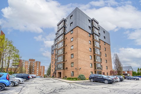 A large brick building with a parking lot in front of it.