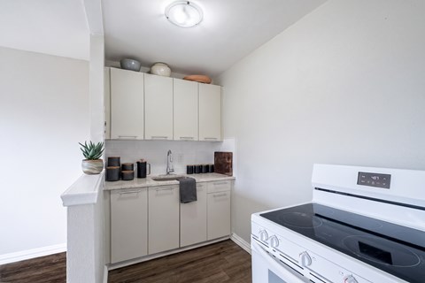 A white kitchen with a white oven and white cabinets.