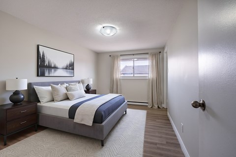 A bedroom with a large bed and a painting on the wall.