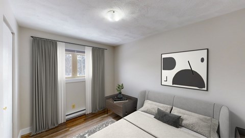 A modern bedroom with a grey bed, a small table with a plant, and a painting on the wall.