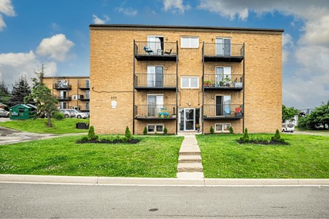 A brick building with a green lawn in front.