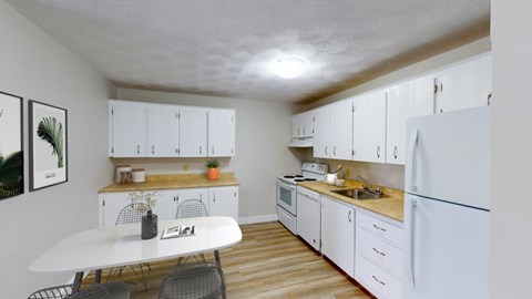 A kitchen with white cabinets and a white fridge.
