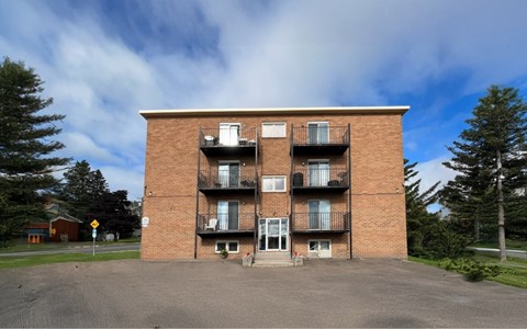 A large red brick building with a balcony on the second floor.