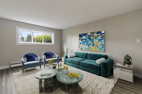 A living room with a green couch, two blue chairs, and a painting on the wall.