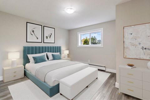 A bedroom with a large bed and a window showing trees outside.