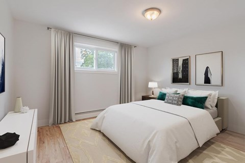 A bedroom with a large bed and a window with curtains.