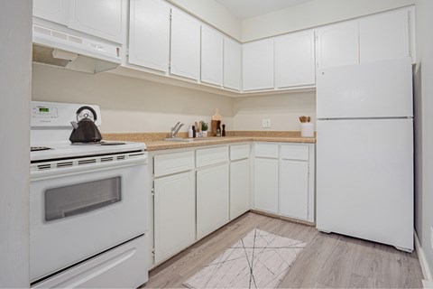 A kitchen with white appliances and cabinets.