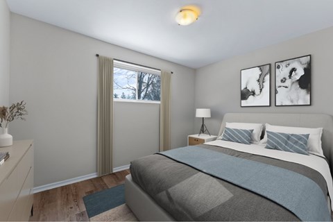 A bedroom with a large bed and two pictures on the wall.