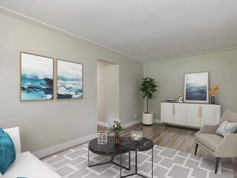 A living room with a white couch, a black coffee table, and two paintings on the wall.