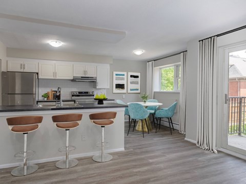 A kitchen with a bar area and a dining table with chairs.