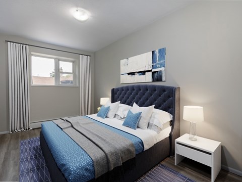 A bedroom with a large bed and a nightstand with a lamp.