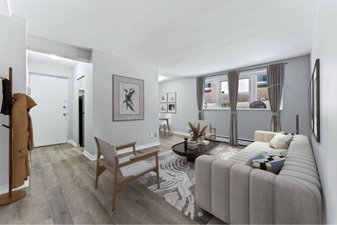 A living room with a grey sofa and a wooden chair.