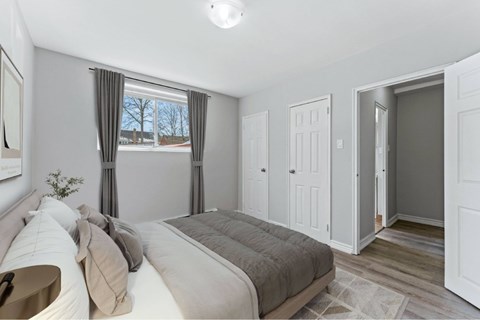 A bedroom with a large bed and a window with curtains.