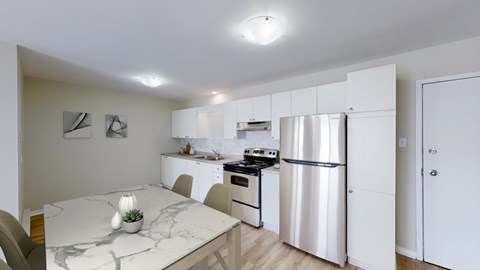 A kitchen with a refrigerator, stove, and oven.