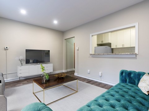A living room with a white cabinet, a blue couch, and a mirror on the wall.