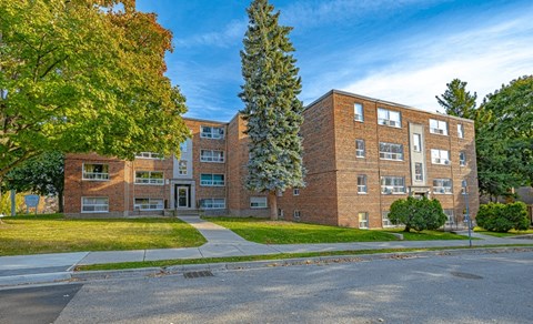 A large brick building with a tree in front of it.