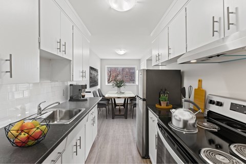 A modern kitchen with a stove, sink, and countertop.