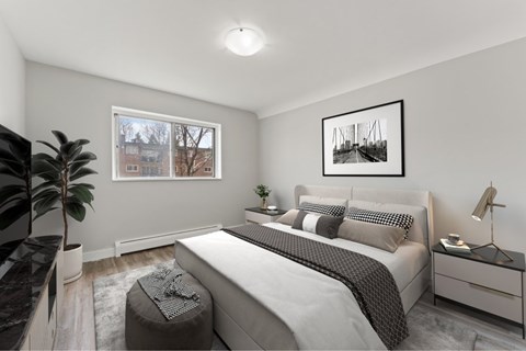A bedroom with a large bed, a window, and a painting on the wall.