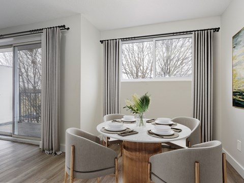 A dining room with a table set for four.