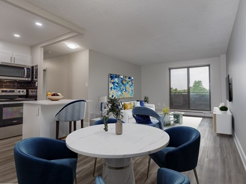 A modern dining room with a white table and blue chairs.