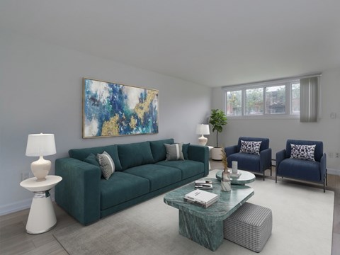 A living room with a green couch and a painting on the wall.