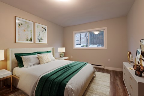 A bedroom with a bed, nightstand, and two framed pictures on the wall.