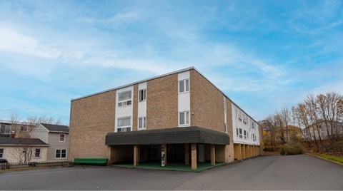 A large building with a parking lot in front.