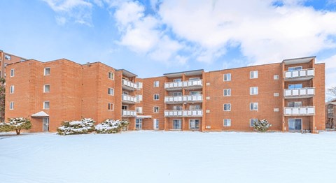 A red brick building with a snowy ground in front.