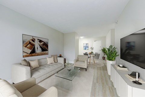 A living room with a white couch, a glass coffee table, and a painting on the wall.