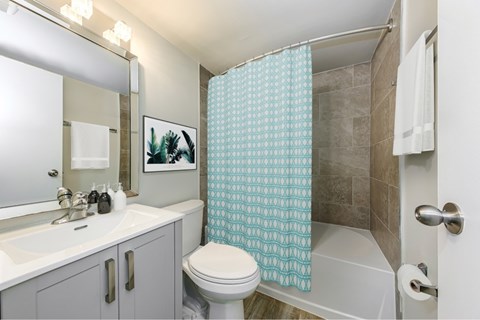 A bathroom with a white toilet, sink, and shower curtain.