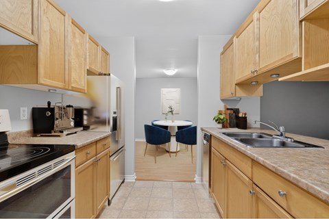 A kitchen with wooden cabinets and a table set for two.