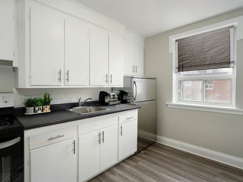 A kitchen with white cabinets and a black stove top.