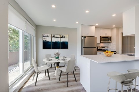 A modern kitchen with a dining table and chairs.