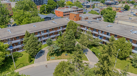 A large apartment complex with a green lawn in the middle.