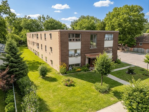 A large brick building with a green lawn in front.