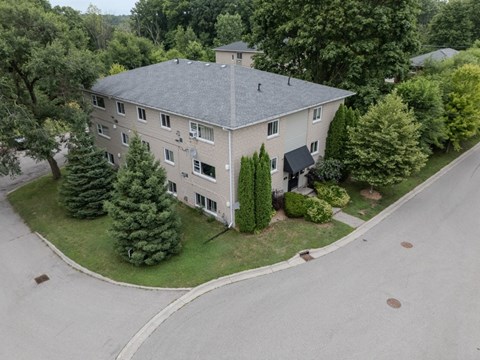 A large house with a grey roof and a driveway in front.