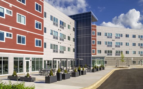 A modern building with a red brick facade and a glass building next to it.