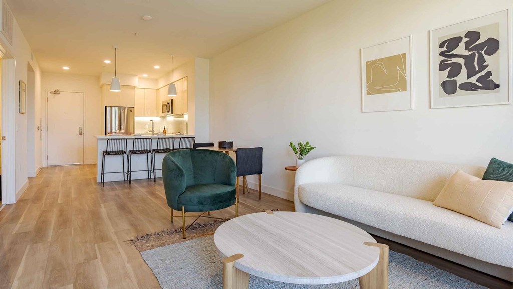 A living room with a white couch, a green chair, and a white coffee table.