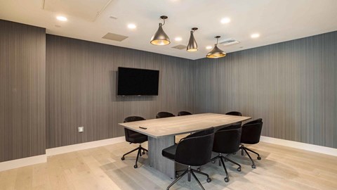 A conference room with a long table and chairs.